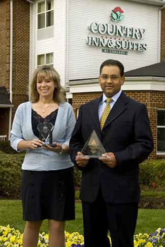 Kimberly Armstead, Vice President of Asset and Revenue Management and Hitesh Patel, CEO are pictured with the Friends Hosting Friends Award and President's Award from Carlson Hotels.